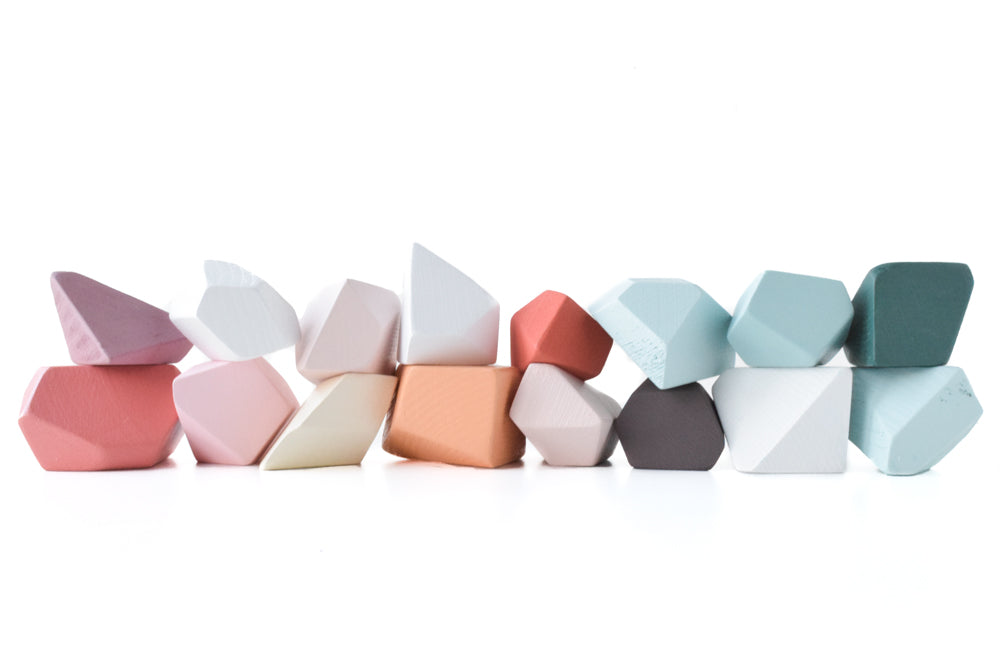 
                  
                    An assortment of rock-shaped blocks in various pastel colors neatly arranged in a row against a white background. The blocks come in shades of pink, white, peach, brown, gray, and different tones of blue and green.
                  
                